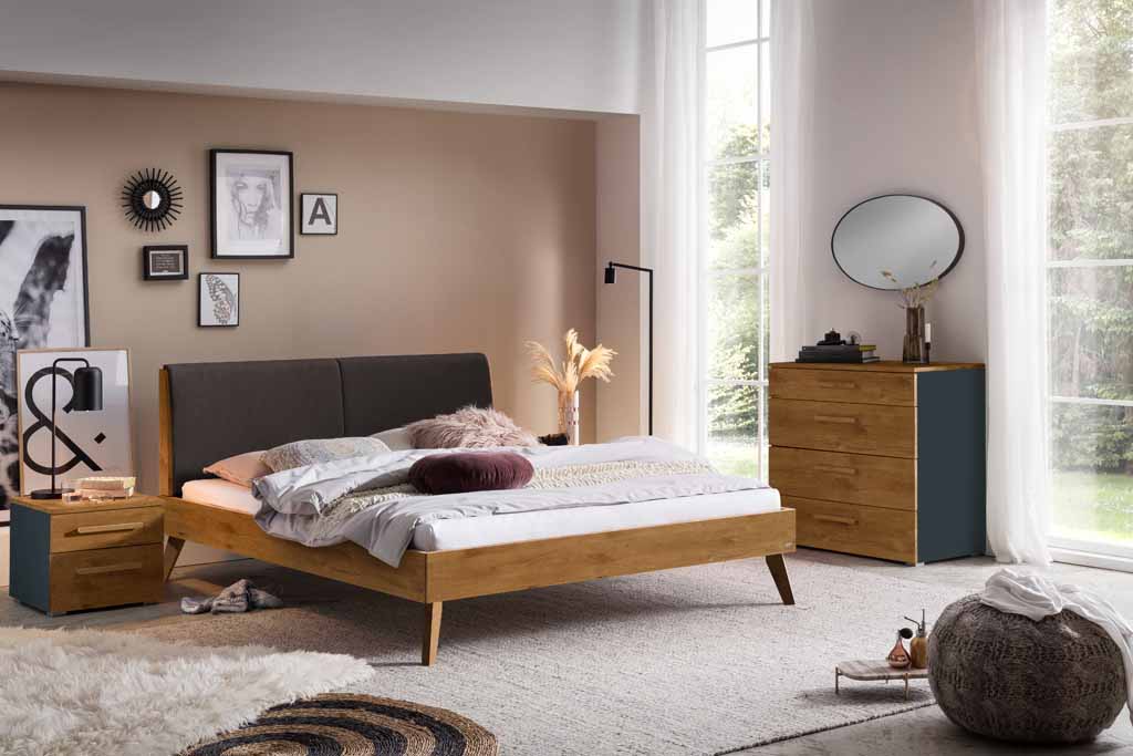 Gemütliches Schlafzimmer mit Doppelbett, Nachttisch, Kommode und dekorativen Details in neutralen Tönen