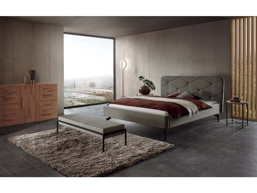 stilvoll eingerichtetes Schlafzimmer mit Bett Bettbank und Kommode in dunklem design mit grauen wänden und einem großen fenster hasena