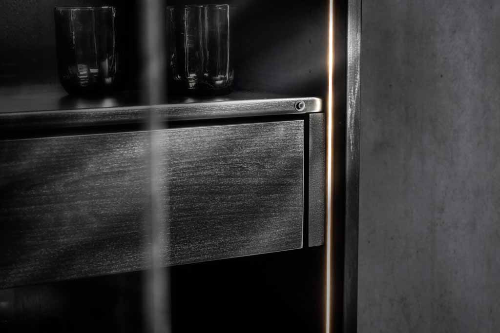 Detailansicht eines modernen, dunklen Regals mit Glasgefäßen und dezenter, indirekter Beleuchtung