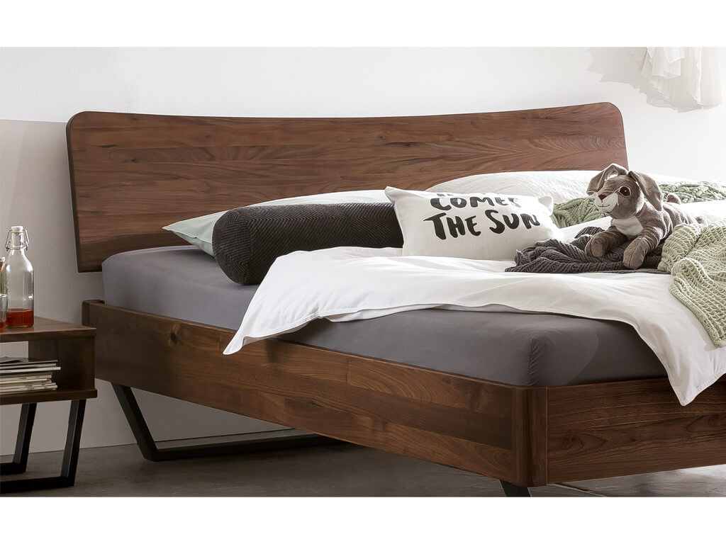 Nahaufnahme des Kopfteils und des Bettrahmens vom Hasena Bett Tresali aus Nussbaum.