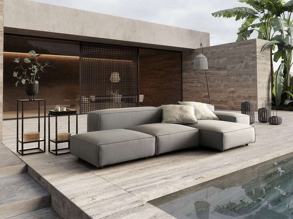 Eine luxuriöse Outdoor-Lounge-Szene mit einem modularen Sofa in Dunkelgrau und hellbeigen Kissen neben einem Pool. Im Hintergrund sind ein modernes Gebäude mit dunklen Fensterfronten, Pflanzen und ein weiterer kleiner Beistelltisch zu sehen.