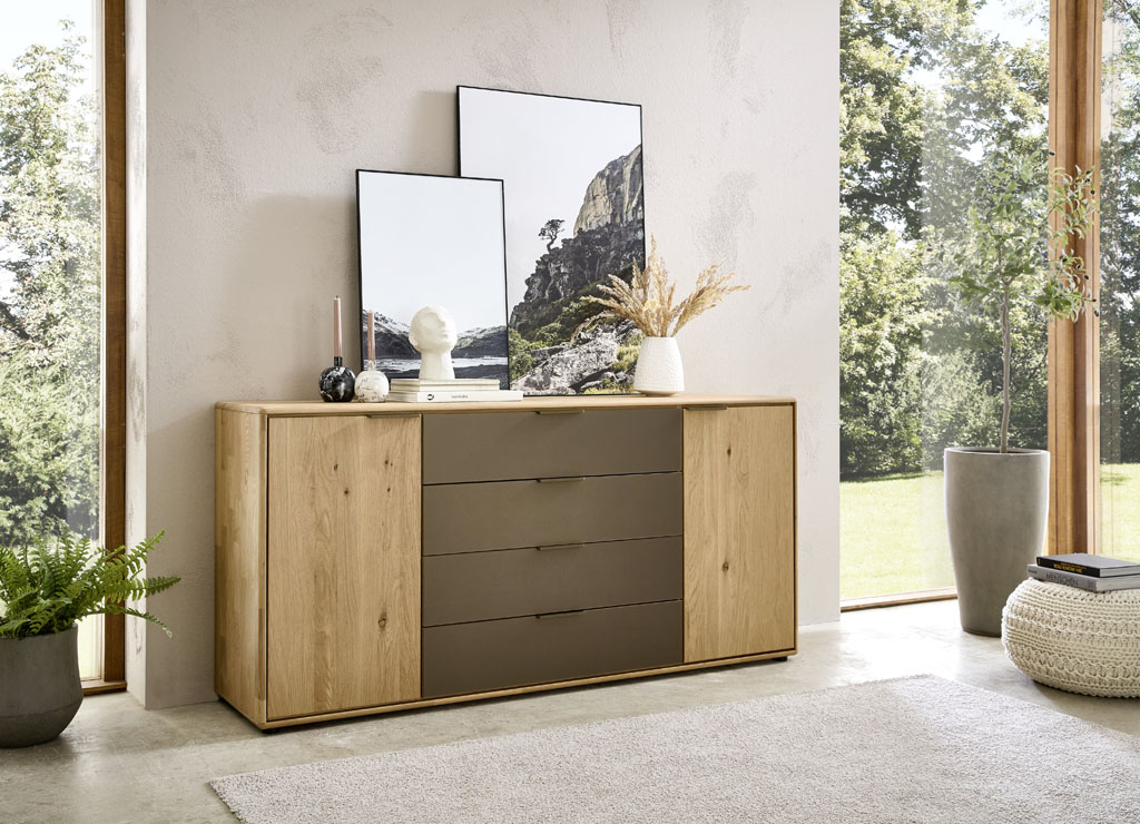 Moderne braune Kommode mit zwei Türen und vier Schubladen stilvoll dekoriert in einem modernen Zimmer