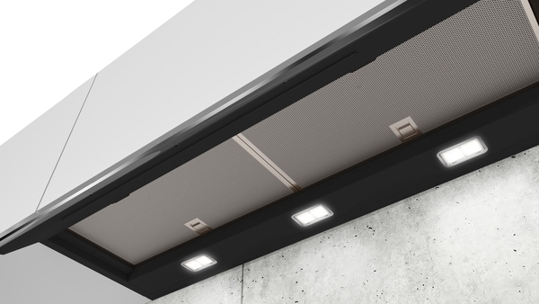 Nahaufnahme einer modernen Dunstabzugshaube mit integrierten LED-Leuchten und Metallfiltern.