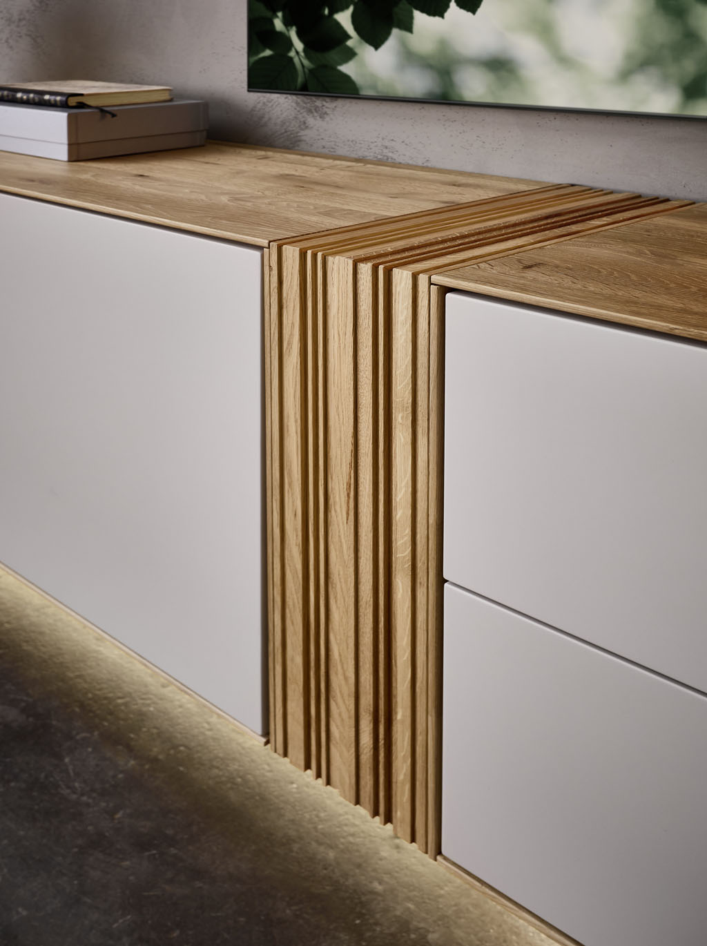 Detailaufnahme eines braun-weißen Lowboards mit markanter Holzakzentverbindung in der Mitte