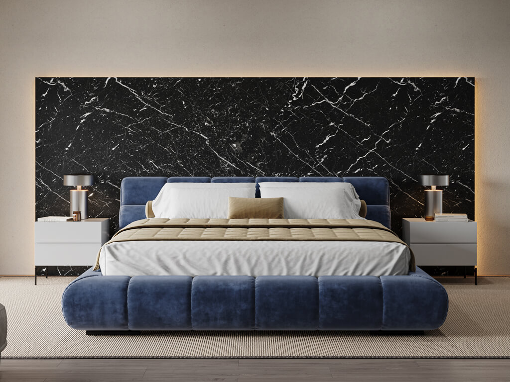 Elegantes Schlafzimmer mit blauem Polsterbett vor einer schwarzen Marmorrückwand, flankiert von modernen Nachttischen und Tischlampen.