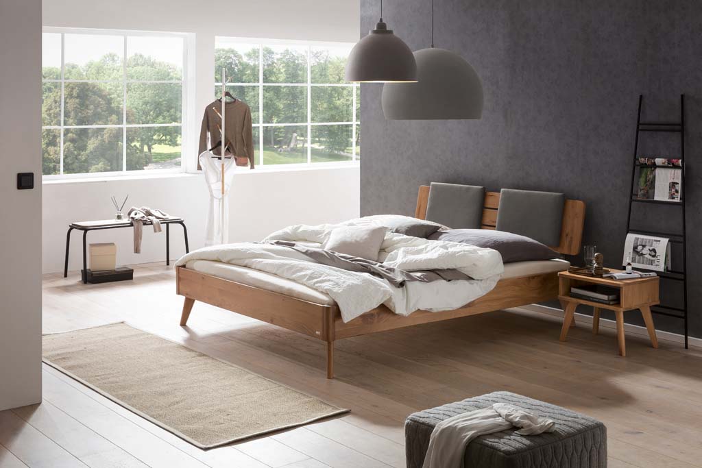 Holzbett mit Holznachttisch in einem stilvoll eingerichten Zimmer