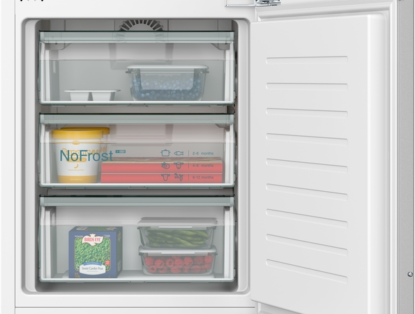 Innenansicht des Gefrierbereichs mit geöffneter Tür und drei transparenten NoFrost-Gefrierschubladen, gefüllt mit Tiefkühlkost.