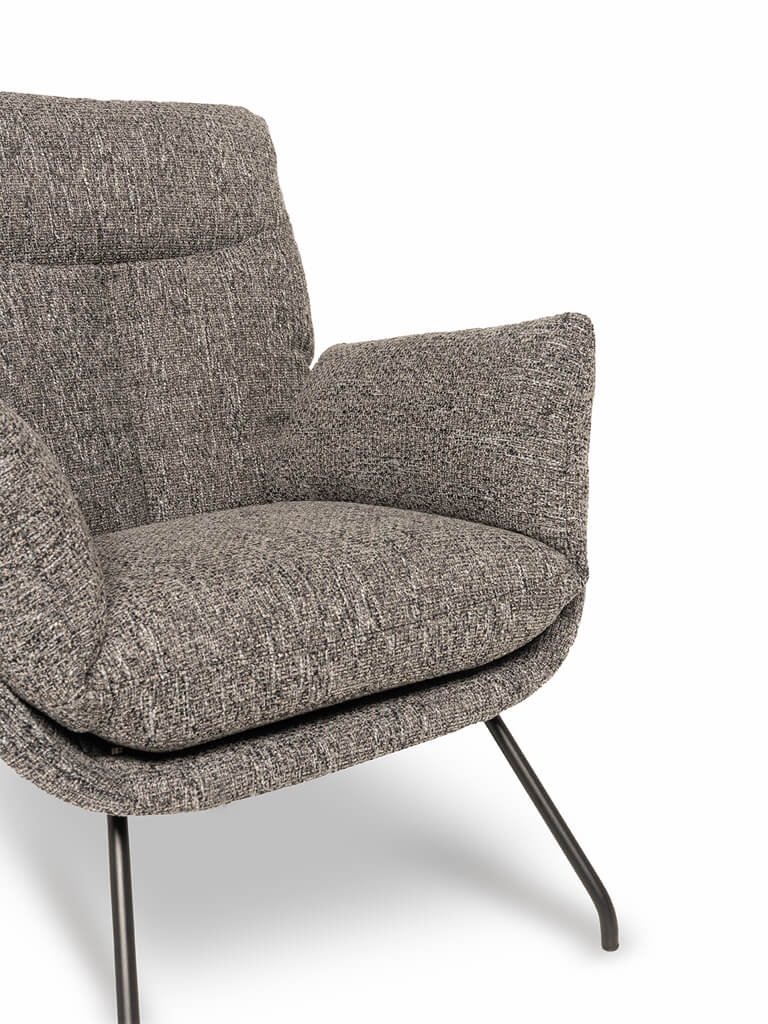 Naheaufnahme eines modernen grauen Sessels mit Metallbeinen und weichem Stoffbezug