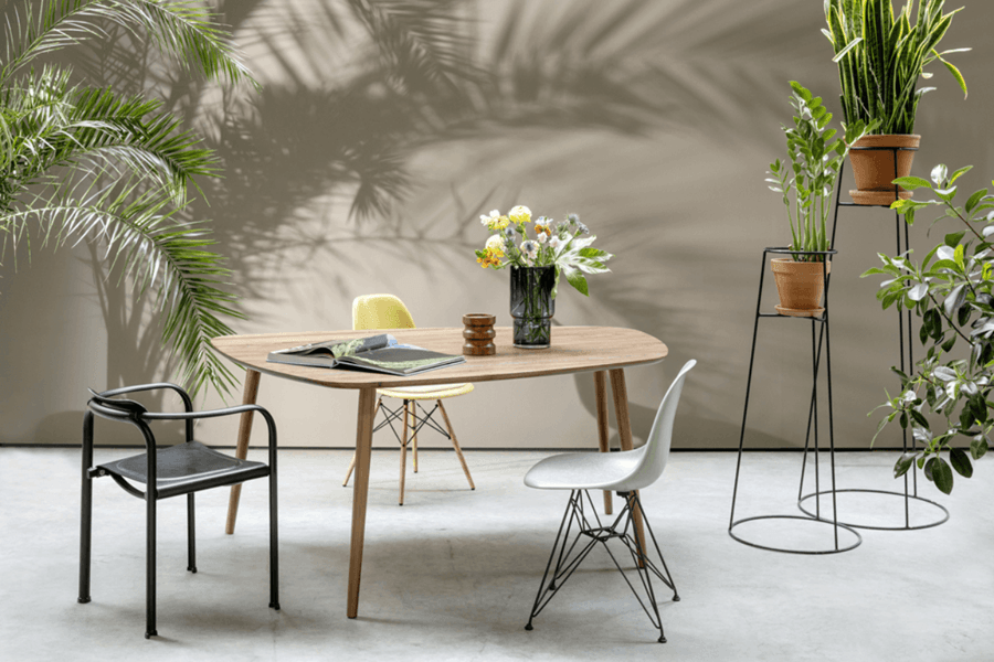 organisch geformter Esstisch aus Holz in einem Esszimmer mit vielen grünen Pflanzen