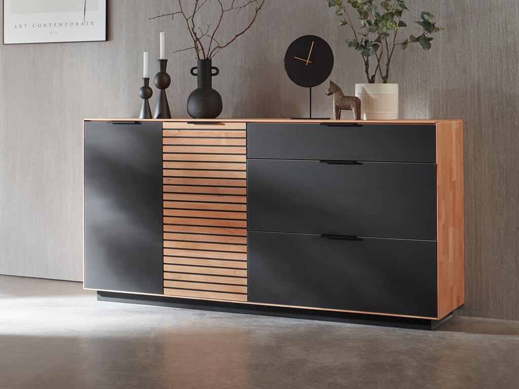Wöstmann WM 2320 - Sideboard  | B: 181,9 cm | Type 2853/2854 Elegante Kommode mit hölzernen und schwarzen Oberflächen, dekoriert mit Kerzen, Vase und Uhr.