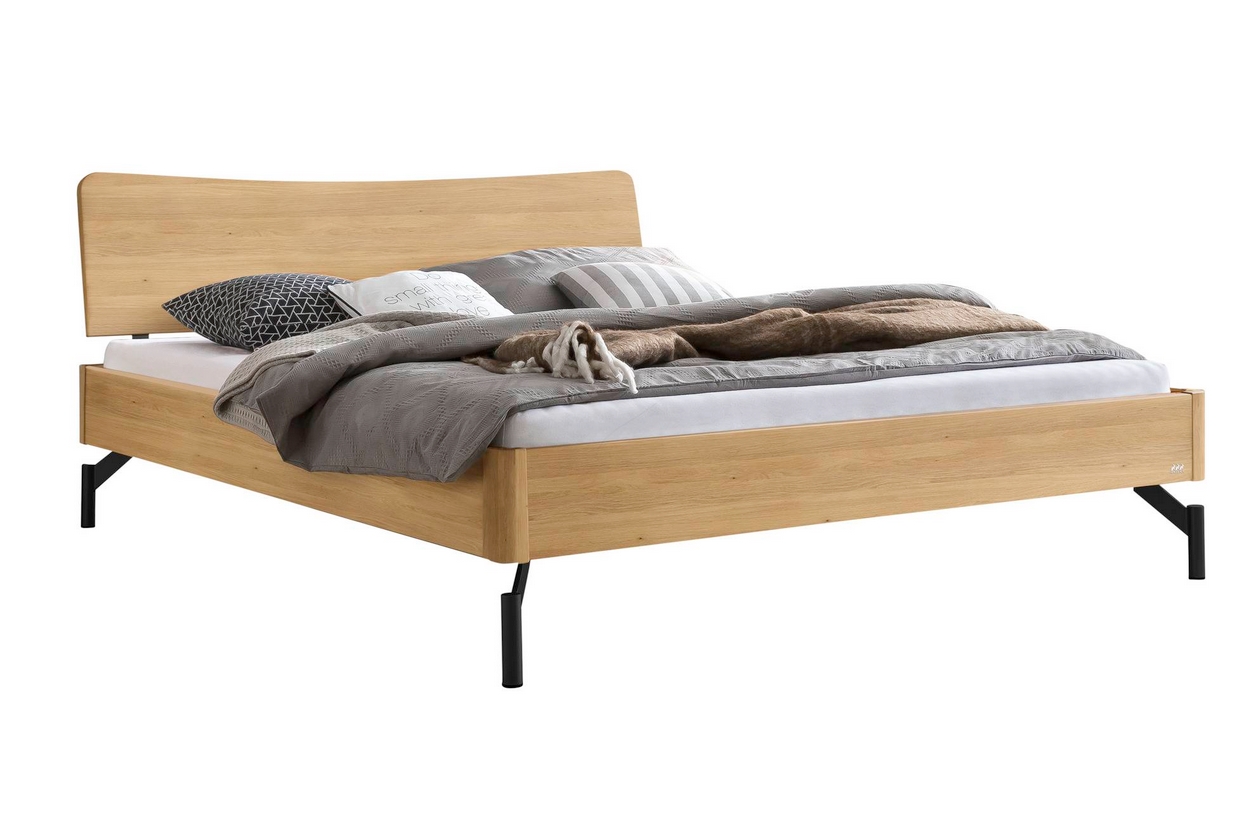 braunes holzbett mit holzkopfteil auf metallfüßen matratze und moderne bettwäsche hasena