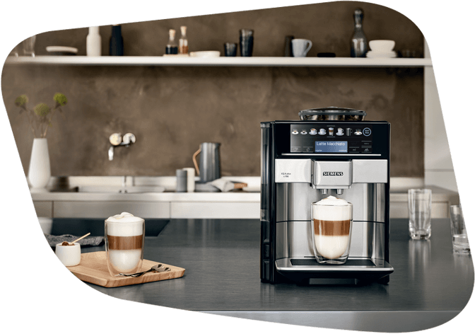 Kaffeemaschine steht auf Arbeitsplatte während ein kaffeehaltiges Heißgetränk zubereitet wird.