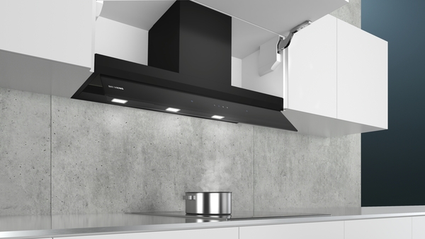 Schwarze Dunstabzugshaube in einer modernen Küche mit minimalistischer Einrichtung und einem Topf auf dem Kochfeld