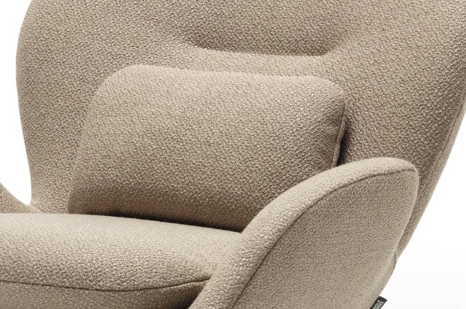 Detailaufnahme eines beigen Polstersessel mit markanten Armlehnen und Rückenkissen vor weißem Hintergrund