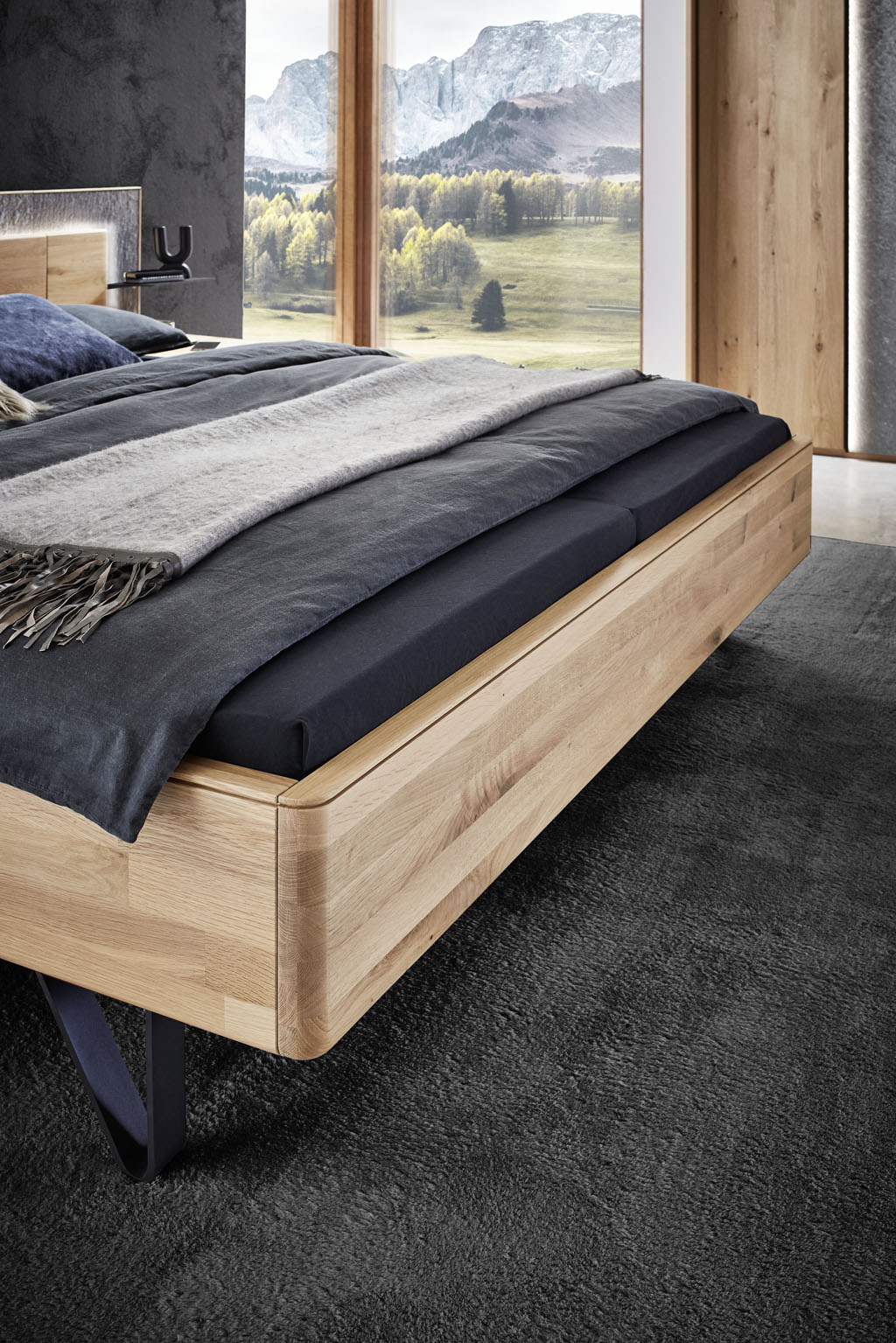 Detaillaufnahme einer brauner Bettecke stilvoll dekoriert in einem hellen Raum