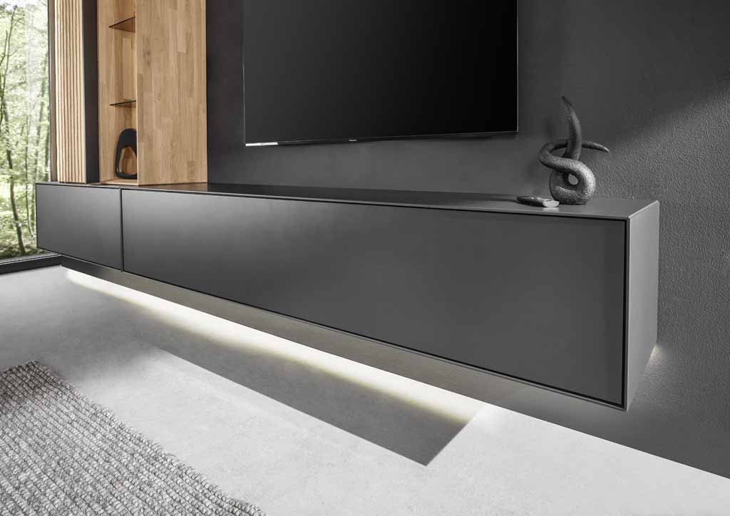 Ein modernes, dunkelgraues TV-Lowboard, das an der Wand schwebt, mit einer Skulptur darauf und einem Bildschirm darüber.