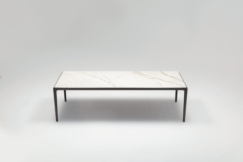 Moderner rechteckiger Tisch mit weißer Marmorplatte und schwarzen Metallbeinen auf hellem Hintergrund