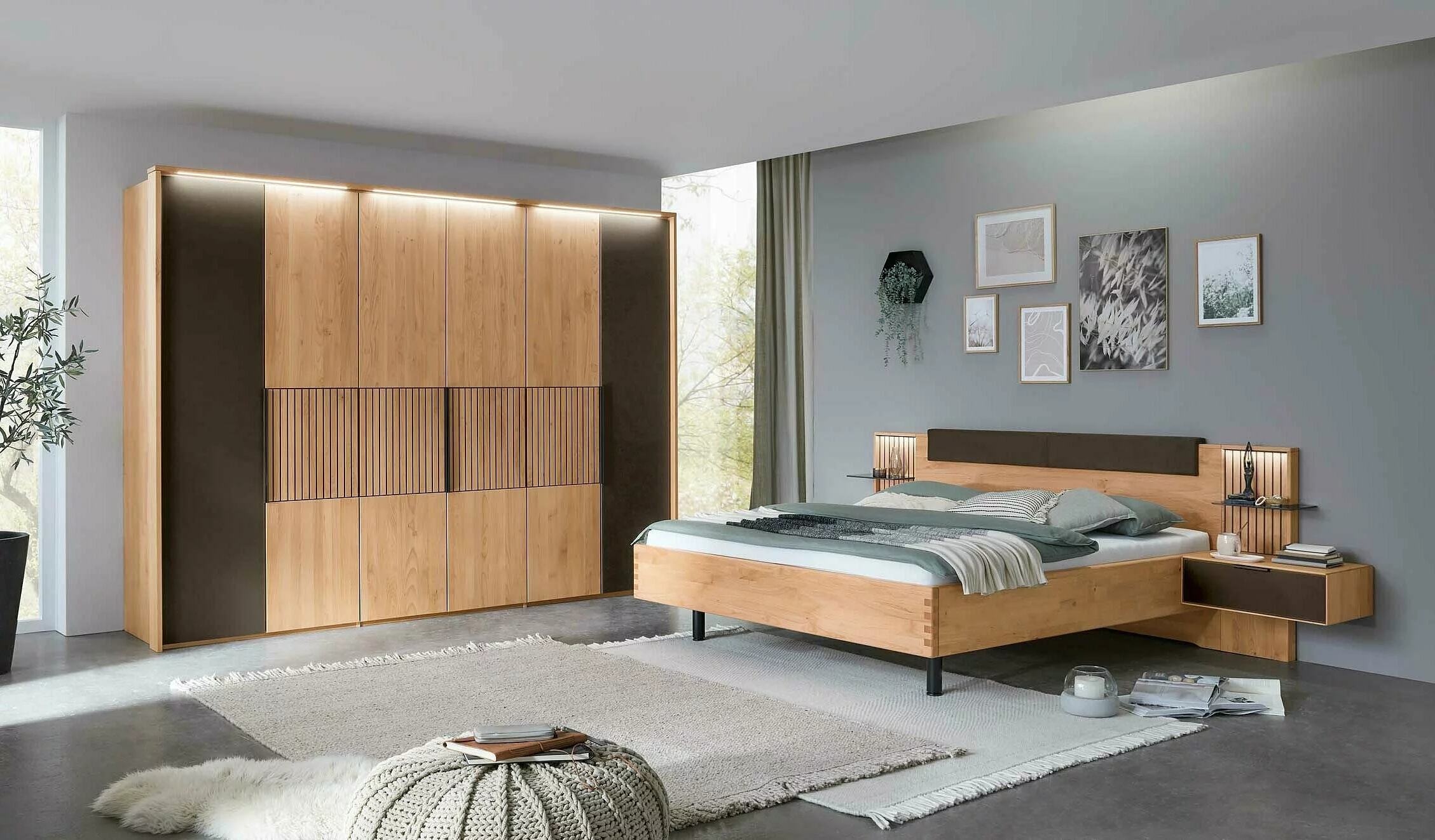 Wöstmann WSM 4400 - Schlafzimmer (Vorzugskombination) | Erle massiv | Schrank 6-türig, Bett 180 x 200 cm, 2 Konsolen Ein stilvolles Schlafzimmer mit einem großen Holzkleiderschrank, einem Eichenbett mit Kopfteilen und Nachttischlampen, dekoriert mit Wandbildern und weichen Textilien.