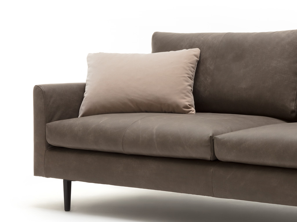 freistil Rolf Benz 134 - Seitenteil-Kissen | 56 x 26 cm Nahaufnahme eines grauen Ledersofas mit beige Kissen auf der Sitzfläche