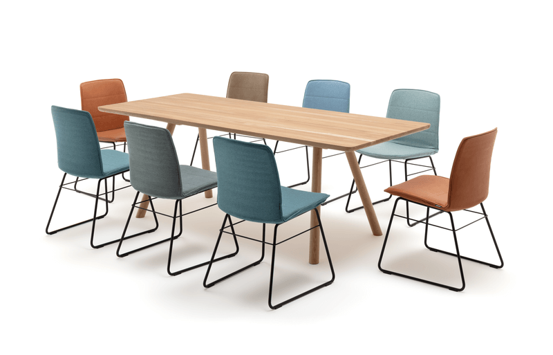 Ein moderner Holztisch mit acht Stühlen in verschiedenen Farben, ideal für Esszimmer