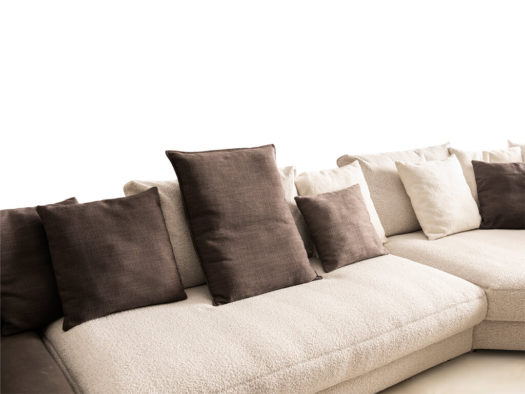 Nahaufnahme eines hellen Sofas mit verschiedenen Kissen in beige und braun Tönen