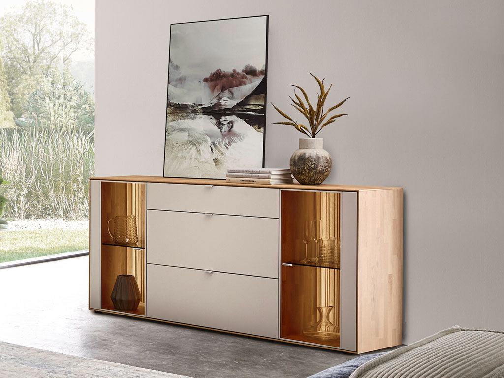 modernes Sideboard mit zwei Vitrinenausschnitten und Beleuchtung in braun-weiß stilvoll dekoriert in einem hellen Raum