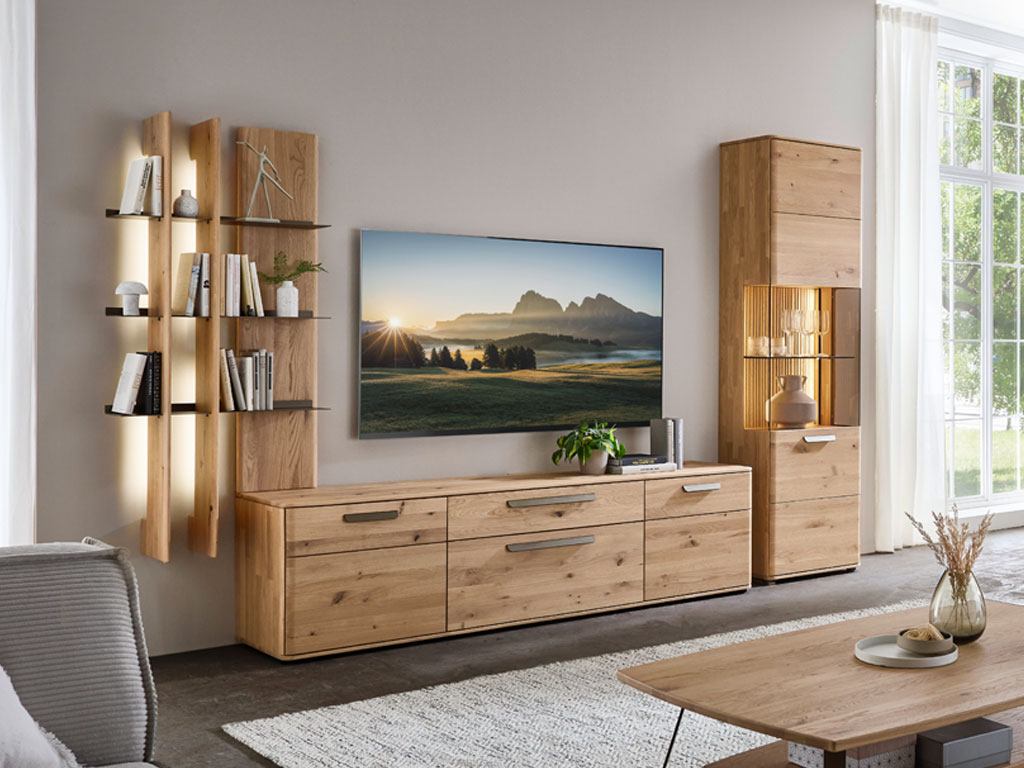 moderne Wohnwand aus Eiche mit einem großen Lowboard, beleuchtetem Regal und beleuchteter Vitrine stilvoll dekoriert in einem modernem Zimmer