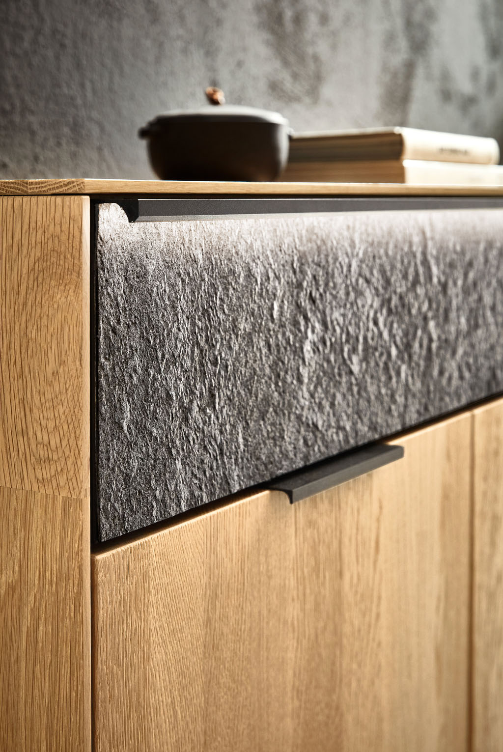 Detailaufnahme einer brauner Holzkommode mit graumeliertere Schublade mit Beleuchtung