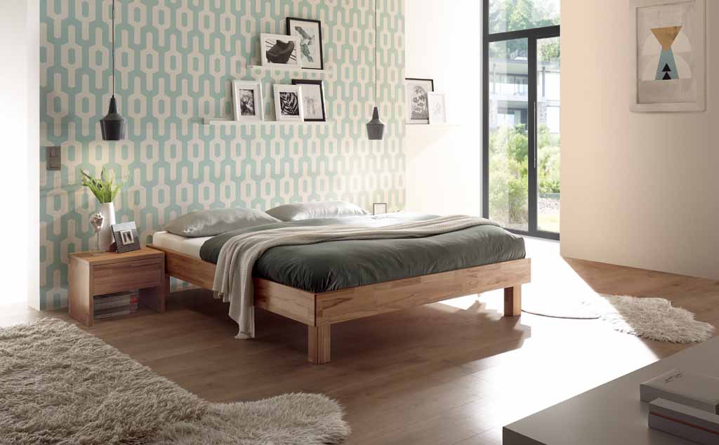 Ein modernes Schlafzimmer mit einem Holzbett, dekorativen Pendelleuchten und geometrischer Tapete.