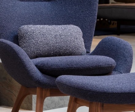 Detailaufnahme eines blauen Polstersessel mit markanten Armlehnen und Rückenkissen