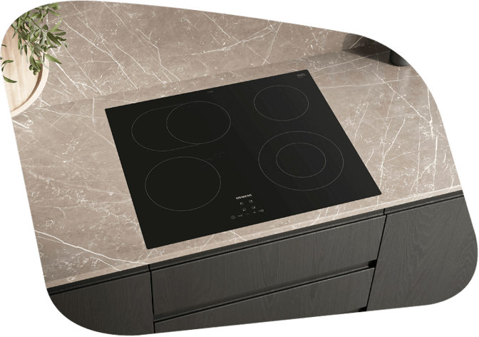Stilvolles Induktionskochfeld mit vier Kochzonen, eingebaut in eine Marmorarbeitsplatte, mit dunkler Küchenkombination