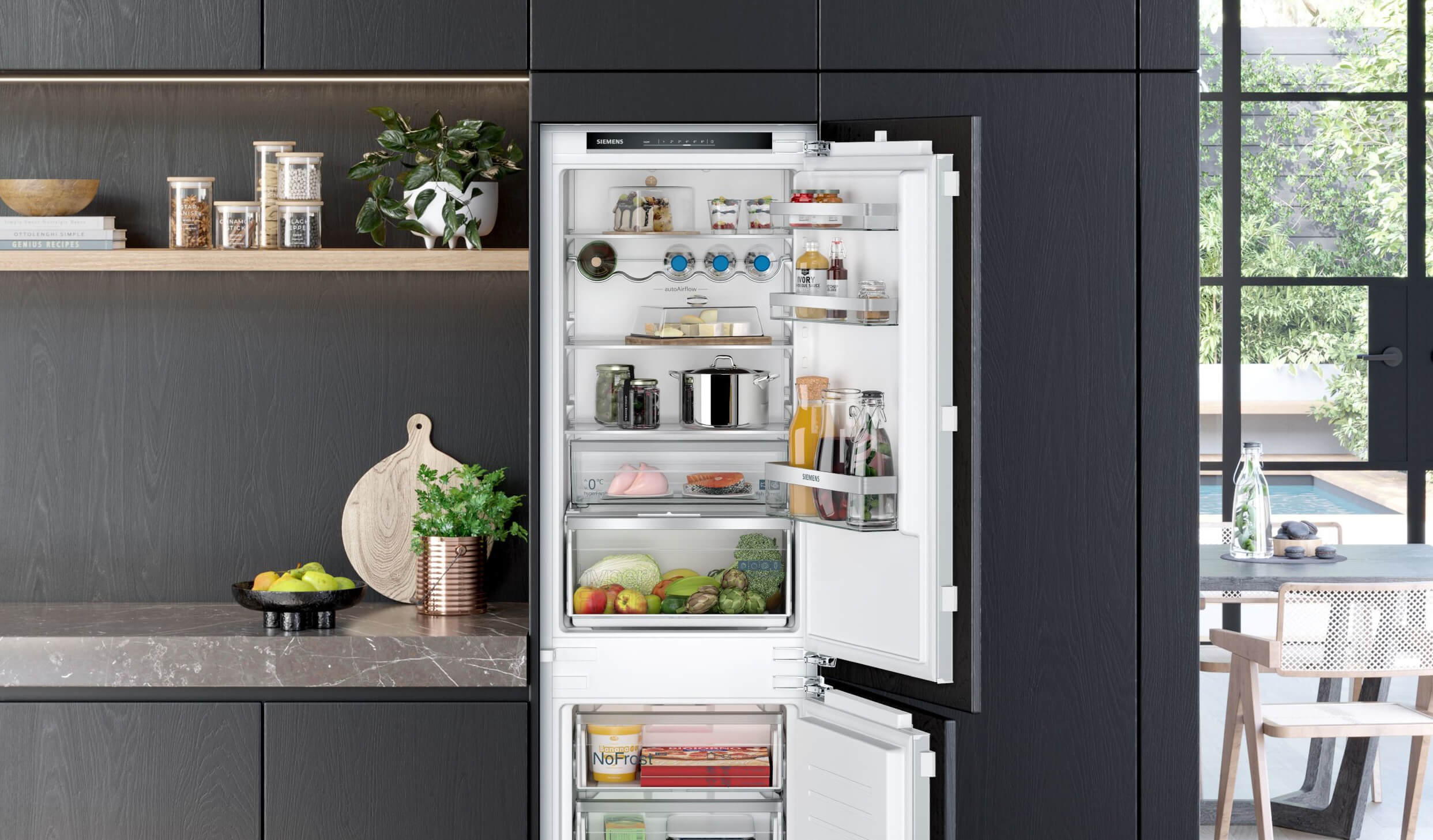 Siemens studioLine Einbau-Kühl-Gefrierkombination in einer modernen grauen Küche mit verschiedenen Dekoelementen. 