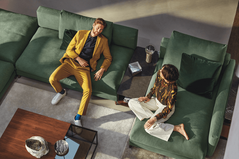 grüne Wohnlandschaft mit Regal als Ablage dazwischen