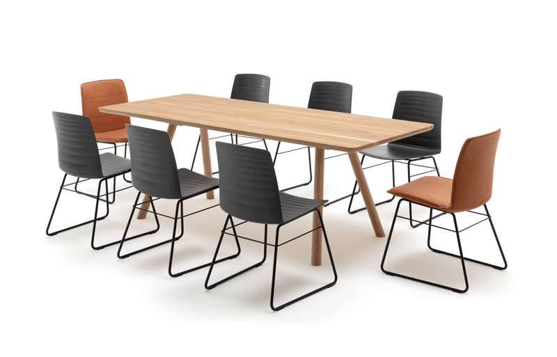 Bild von einem modernen Esstisch aus Holz mit acht modernen Stühlen, sechs in Schwarz und zwei in Orange, auf hellem Hintergrund