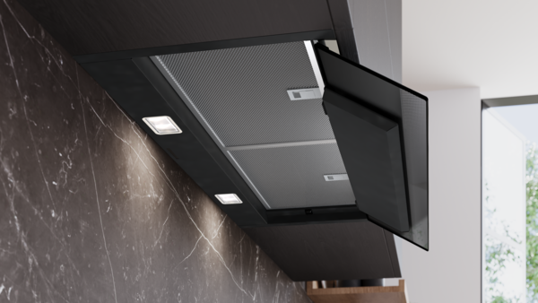 Unteransicht der Dunstabzugshaube mit zwei hellen LED-Leuchten und Blick auf die eingesetzten Metallfettfilter bei leicht geöffnetem Glasschirm.