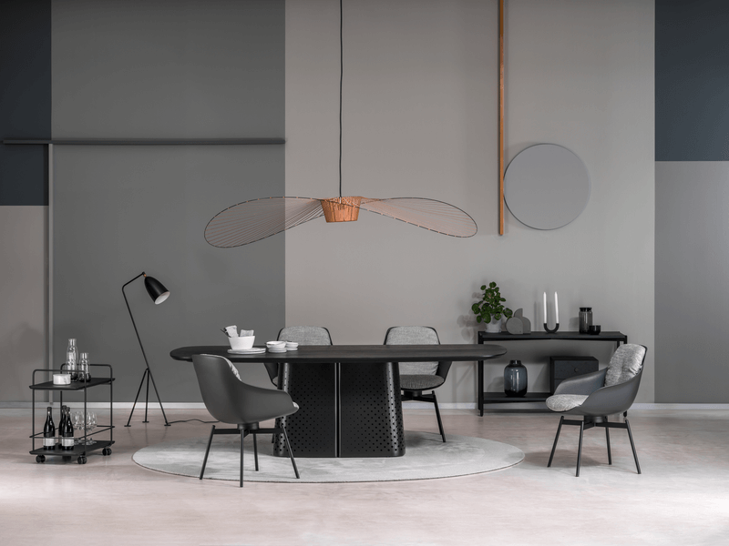 Innenraum mit modernem Esszimmertisch, Designerstühlen, eleganter Hängelampe und stilvollen Dekorationen