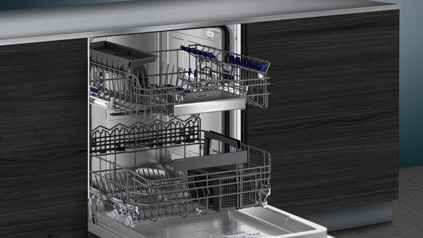 Einbaugeschirrspüler mit geöffneten Türen und herausgezogenen Geschirrkörben in einer modernen, dunklen Küchenumgebung