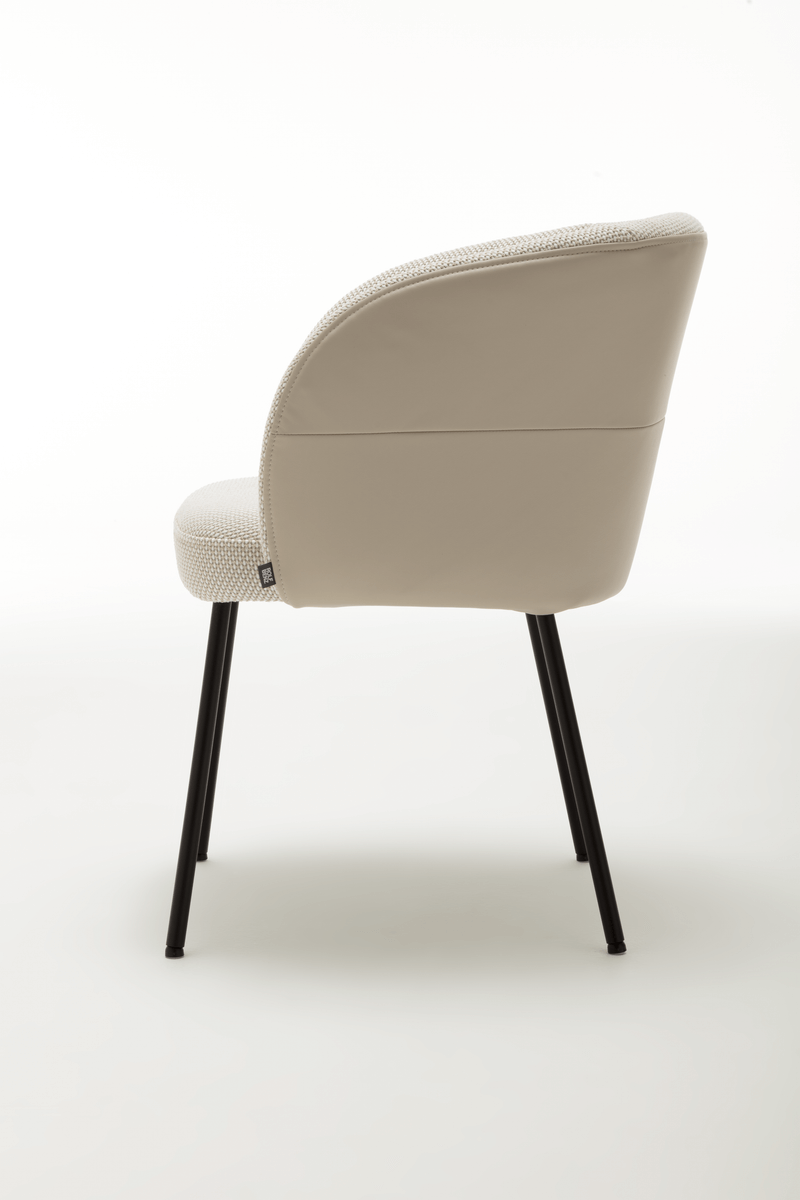 Rückansicht eines stilvollen Esszimmerstuhls in Creme-Weiß mit schwarzem Metallgestell und Textil-Lederkombination. Ideal für modernes Interieur.
