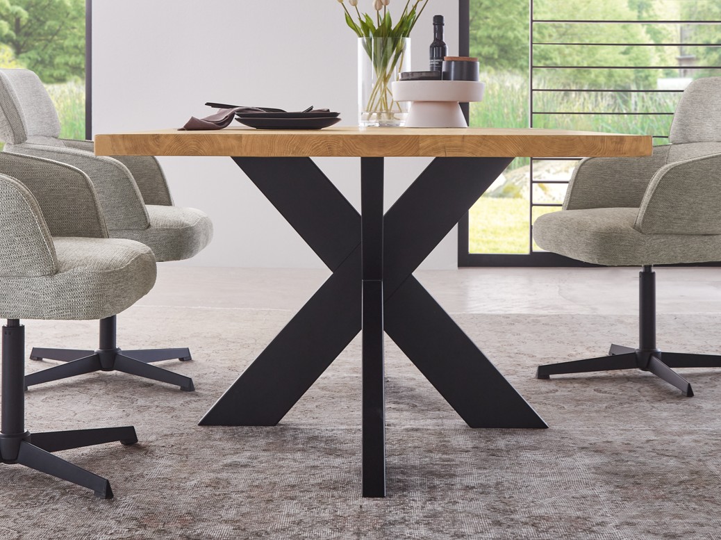 Nahaufnahme eines Holzesstisches mit X-Gestell in schwarz