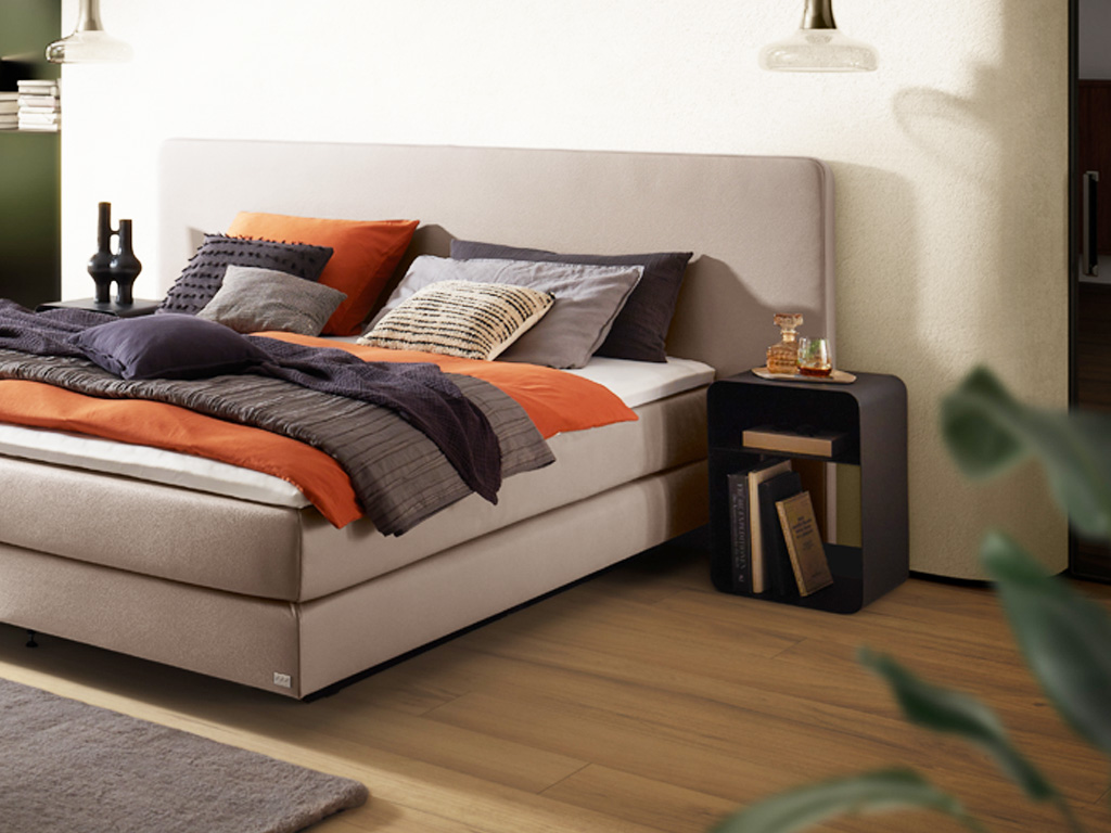 Schwarzer Designernachttische in Form eines Regals mit abgerundeten Kanten vor stilvoll dekoriert an einem Bett in einem modernen Zimmer Austin von Hasena