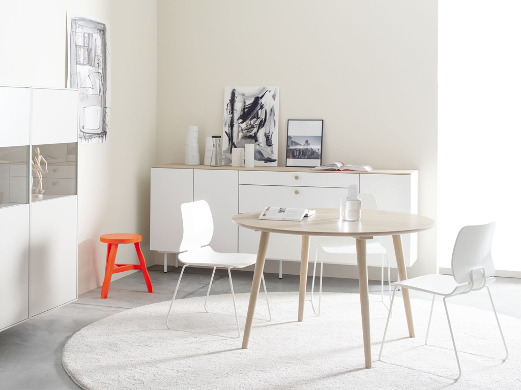 Sudbrock Mellini - Esstisch rund | Ø 120 cm | Eiche milk massiv Minimalistisches Esszimmer mit rundem Holztisch, weißen Stühlen und Dekoration auf weißem Teppich