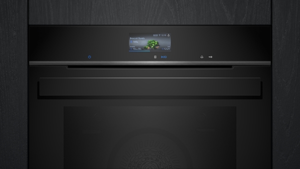 Nahaufnahme eines modernen schwarzen Backofens mit digitalem Display, das Informationen anzeigt.