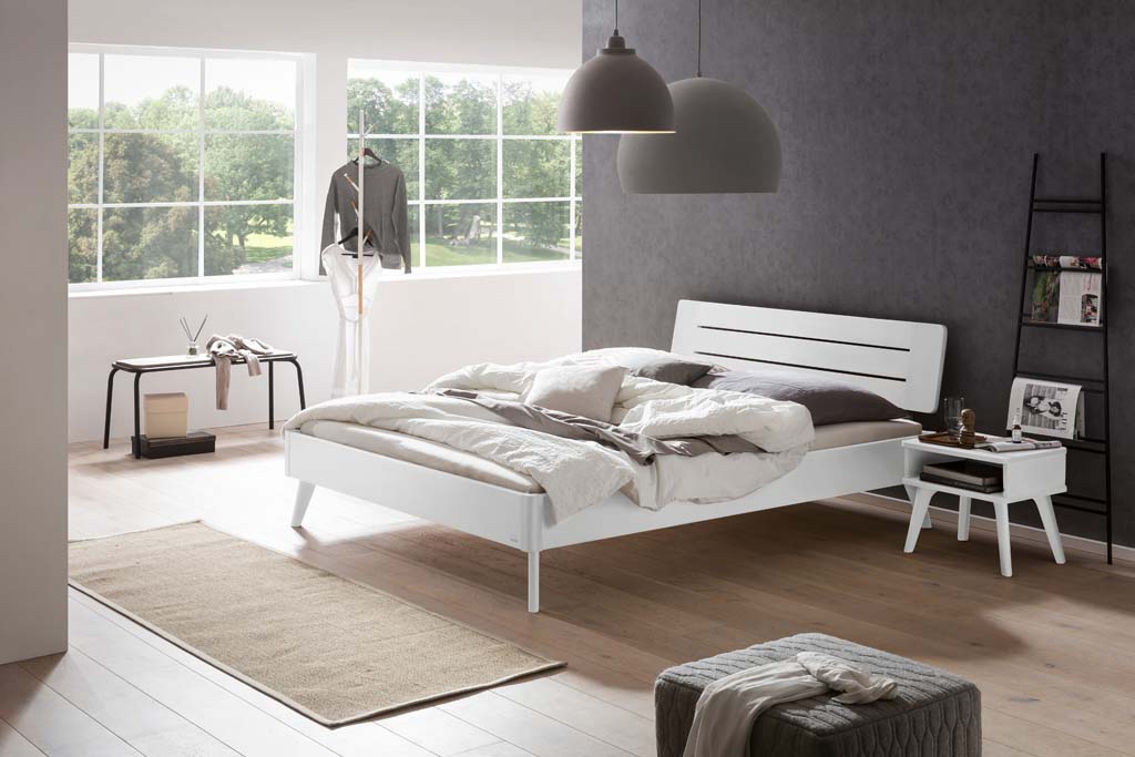 Holzbett mit Holznachttisch in einem stilvoll eingerichten Zimmer