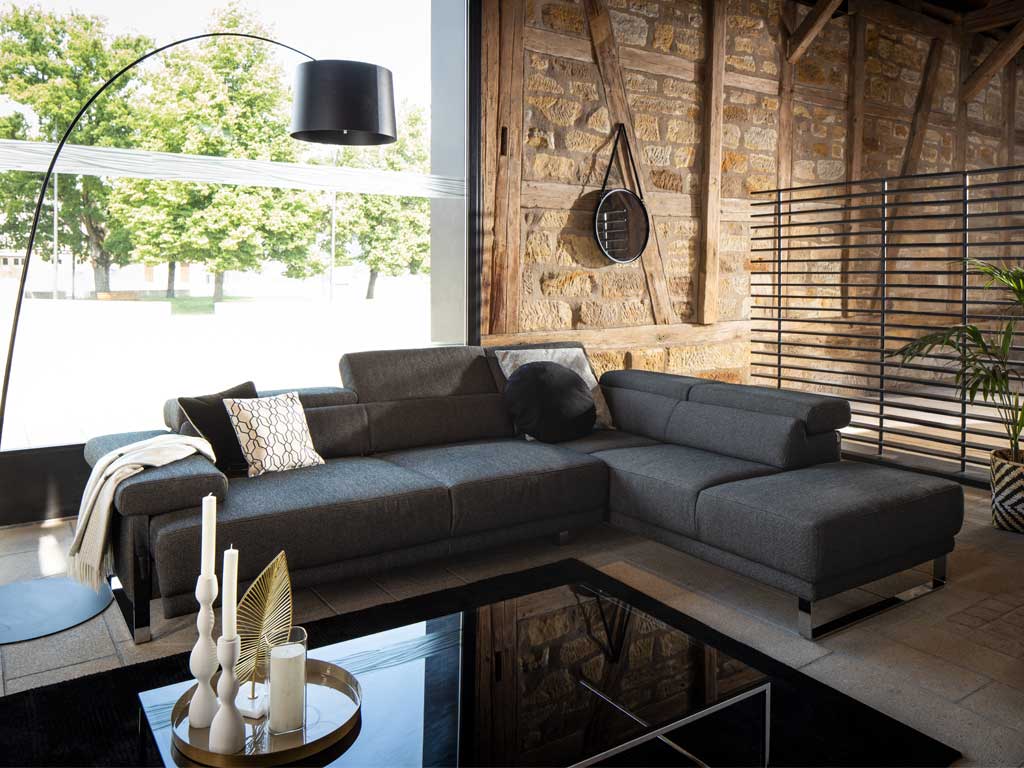 dunkelgraue Couch in Scheune mit Steinwand
