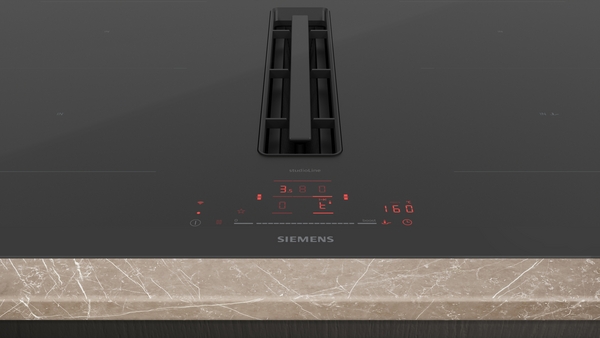 Detailansicht eines modernen Kochfelds mit integriertem Dunstabzugssystem und digitaler Anzeige