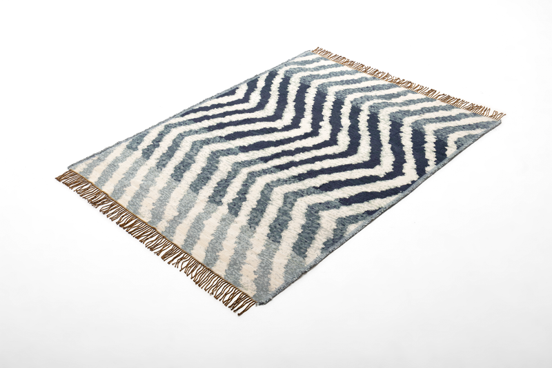 Rolf Benz 975 - Plaid mit Fransen (Grünblau) | 100 % Viskose | 140 x 185 cm Blauer und weißer Teppich mit Zickzack-Design und Fransen an den Enden, auf weißem Hintergrund