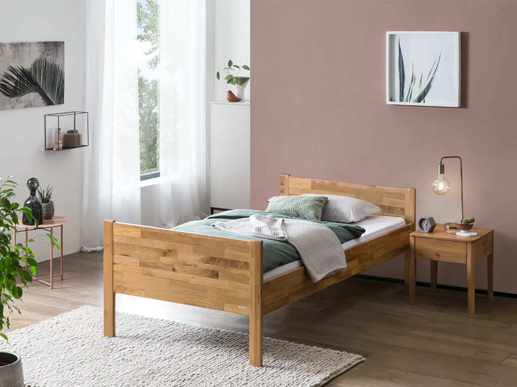 braunes Holzbett mit Nachttisch und Lampe stilvoll dekoriert in einem modernen Zimmer
