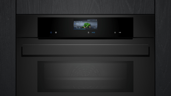 Nahaufnahme der Bedienblende des schwarzen Siemens Backofens mit Fokus auf das leuchtende Display und die glatte Glasfront.