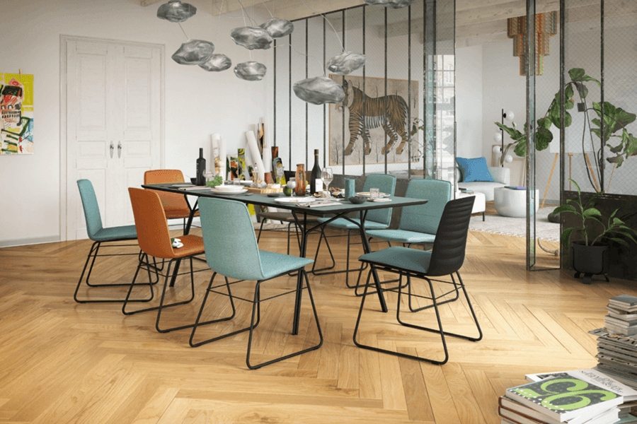 Esszimmer mit Tisch und verschieden farbigen Stühlen