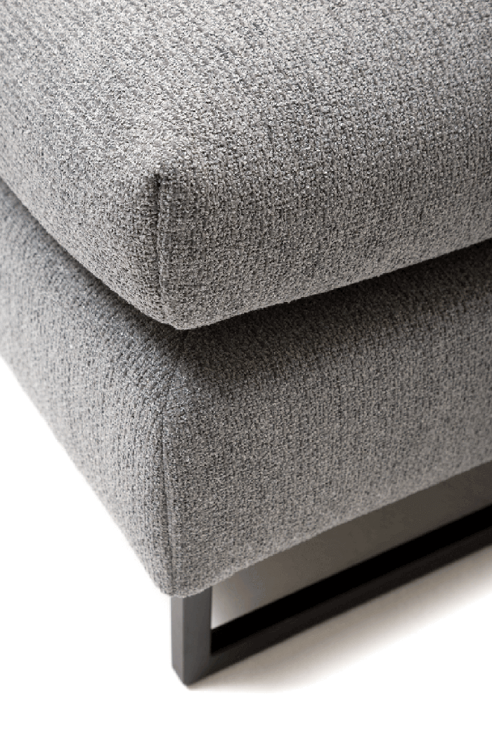Nahaufnahme einer grauen, strukturierten Polsterung und einem schwarzen Metallrahmen eines Sofas
